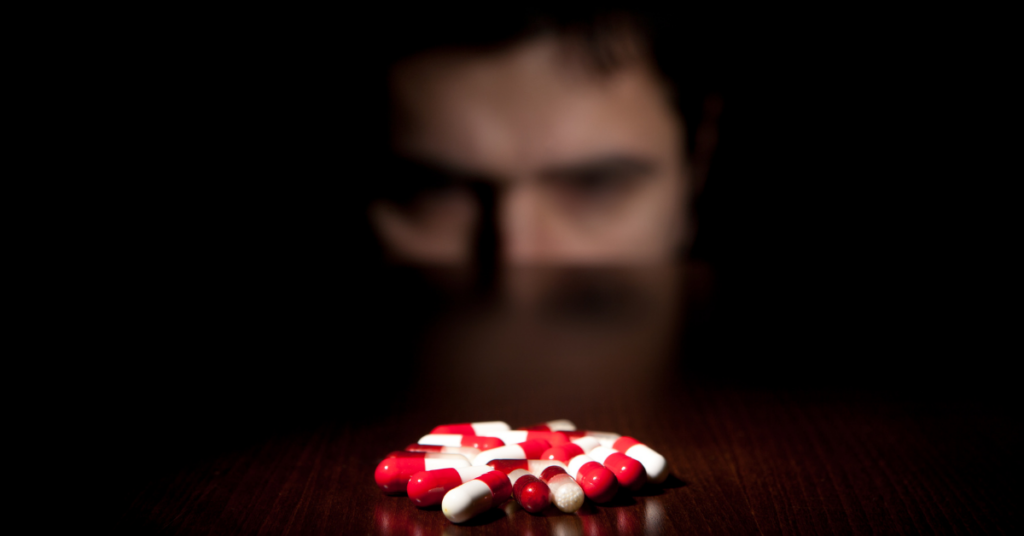 Someone looking at a pile of pills on a table