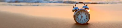 Alarm clock on the beach during sunset