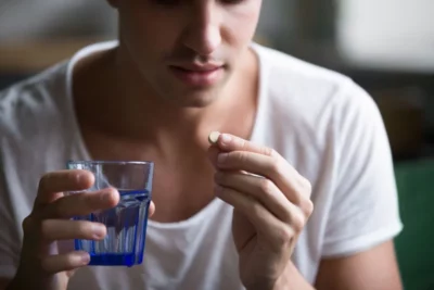 A man taking an adderall pill