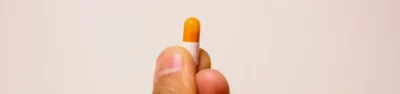 hand holds up a single Adderall pill