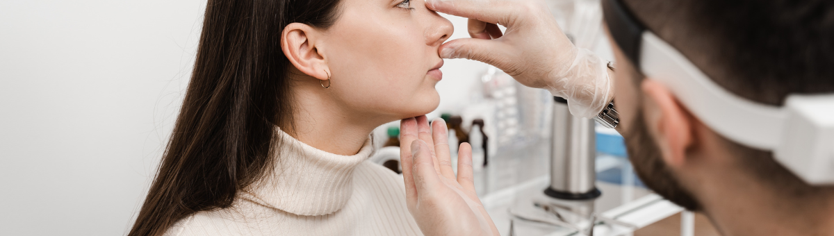 A woman's nose is inspected by a medical professional.